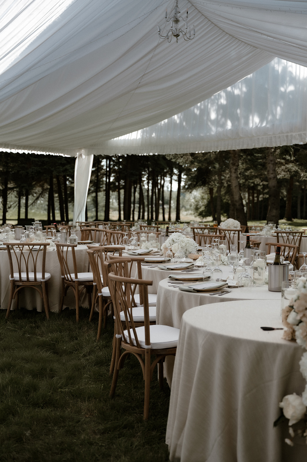 Elite Tents tented reception with candlelit glow and curved caterpillar dinner layout